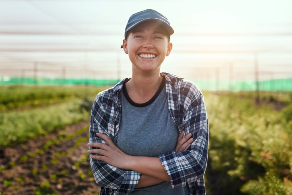 A smiling farm sitter standing in a field